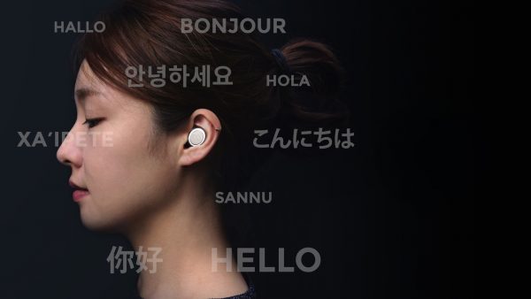 A woman wearing an Mymanu CLIK earpiece, surrounded by the word "Hello" in different languages.